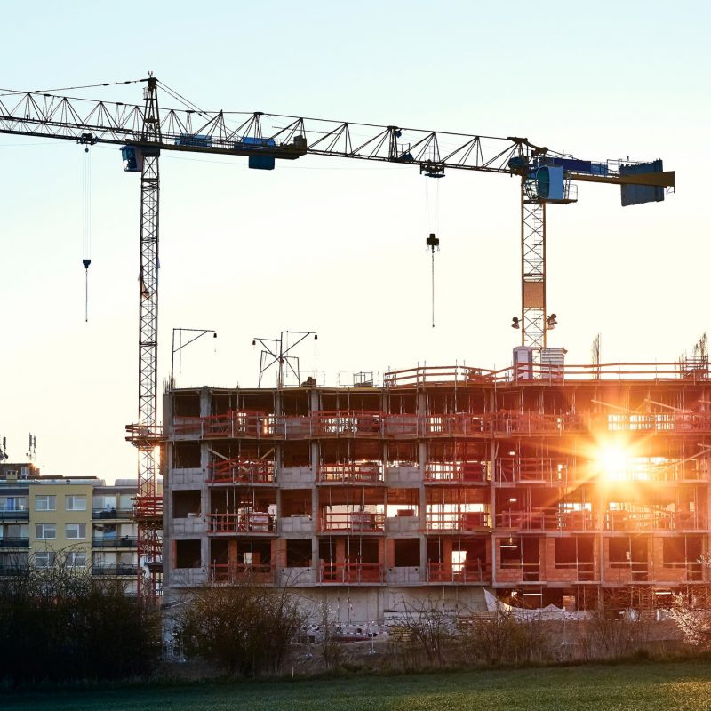 Construction site with cranes at the amazing sunrise. Construction of the new residential building.